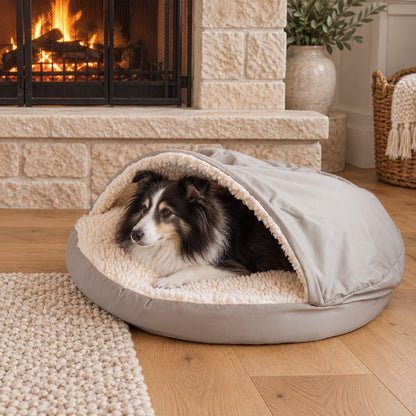 Dog resting in a hooded cave bed