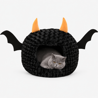 Grey British Shorthair resting inside a black bat pet cave