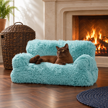 Blue fluffy pet sofa with a cat beside a fireplace